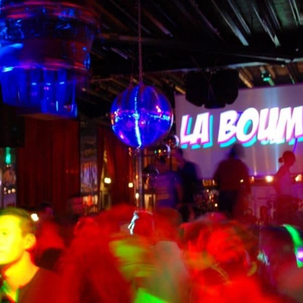 La Boum Schriftzug, Discokugel und tanzende Gäste im Club