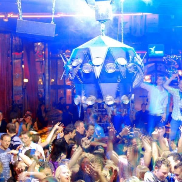Feiernde Menge bei der La Boum Party mit großer Discokugel