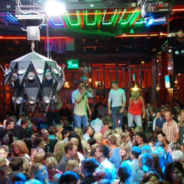 Publikum bei der La Boum Party unter grünem Licht und Discokugel
