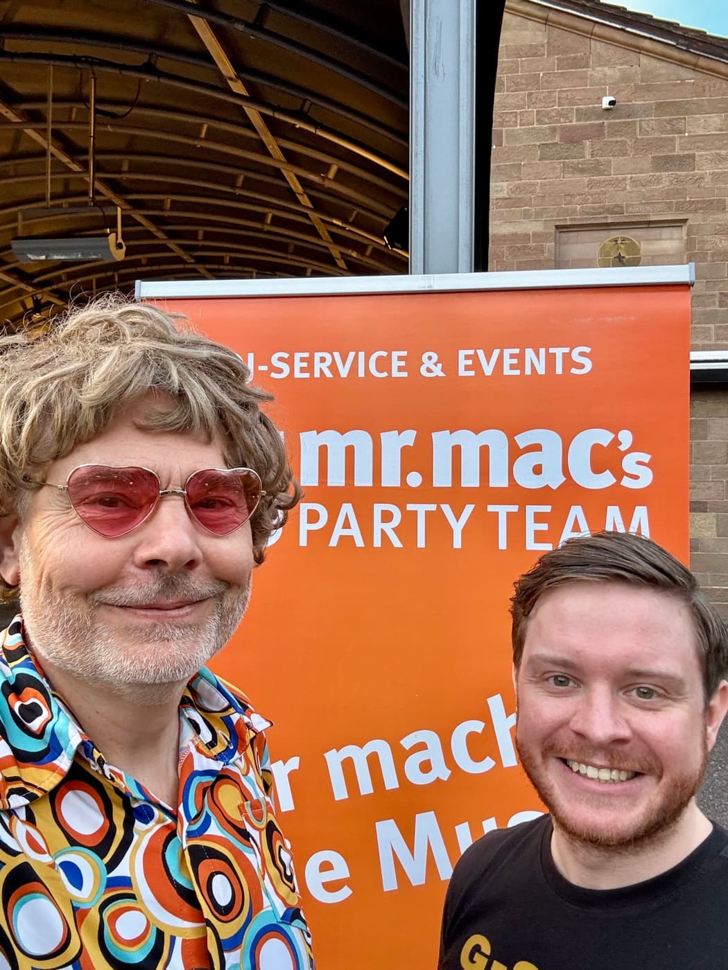 DJ mr. mac und DJ Callix von mr. mac’s party team vor dem Roll-up der DJ-Agentur am Perkins Park