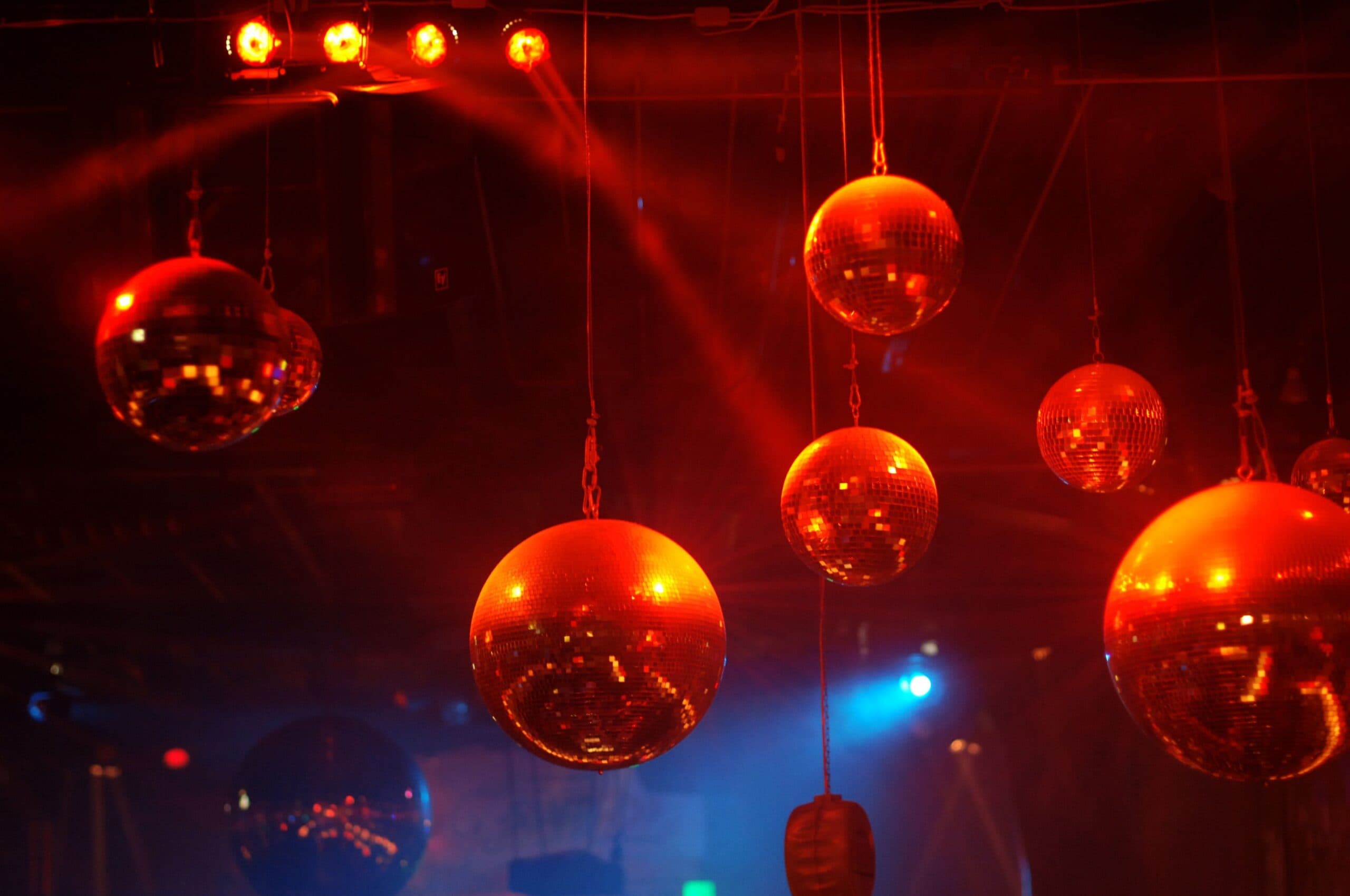 Spiegelkugeln bei der 80er Party La Boum in der BOA Stuttgart – Leuchtende Discokugeln unter rotem und blauem Licht sorgen für authentische Retro-Atmosphäre. Ein Event von Mrmacs Party Team