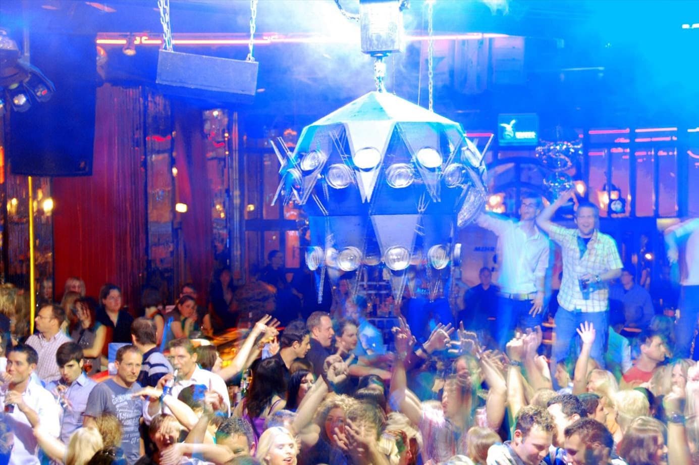 La Boum 80er-Party in der BOA Stuttgart – Tanzende Menge unter bunter Lichtshow und futuristischem Kronleuchter