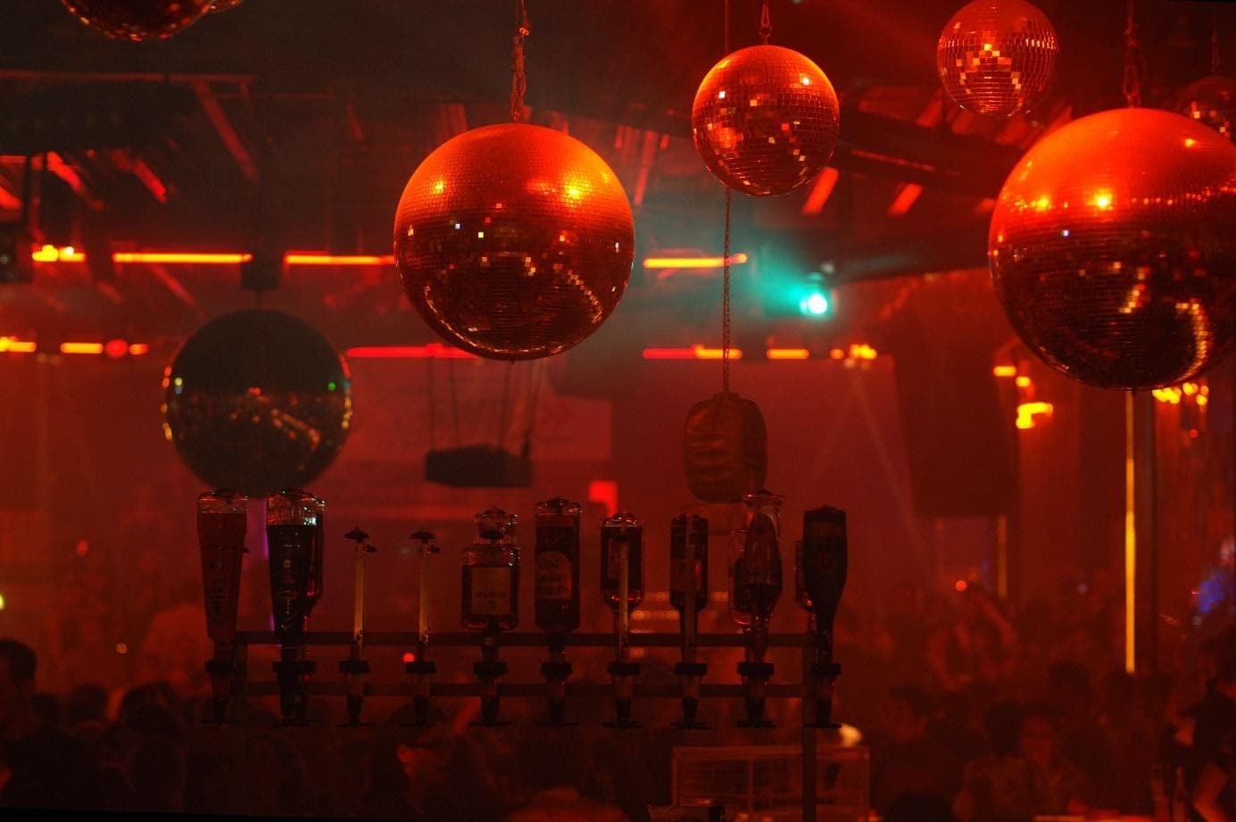 Discokugeln und Barbereich bei der 80er-Party La Boum in der BOA Stuttgart – Retro-Atmosphäre mit rotem Licht