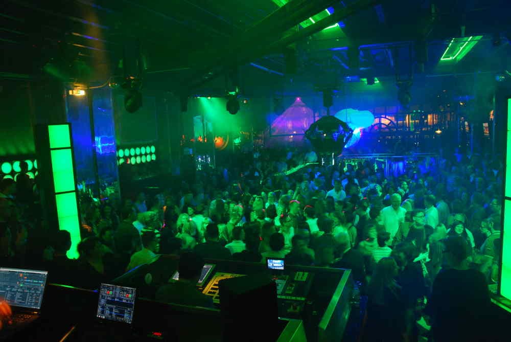 Club-Party mit voller Tanzfläche und grüner Lichtshow