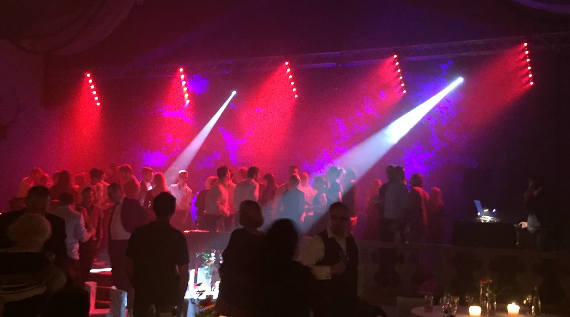 Firmenfeier mit Gästen auf der Tanzfläche und bunter Lichtshow