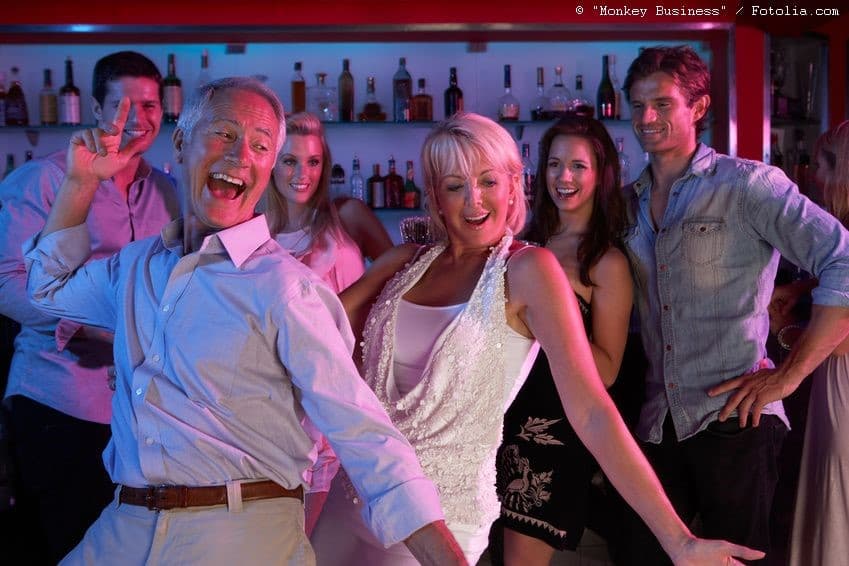 Gut gelaunte Gäste feiern einen Geburtstag an der Bar
