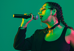Sängerin mit Mikrofon als Motiv für die Karaoke-Liste nach Künstler