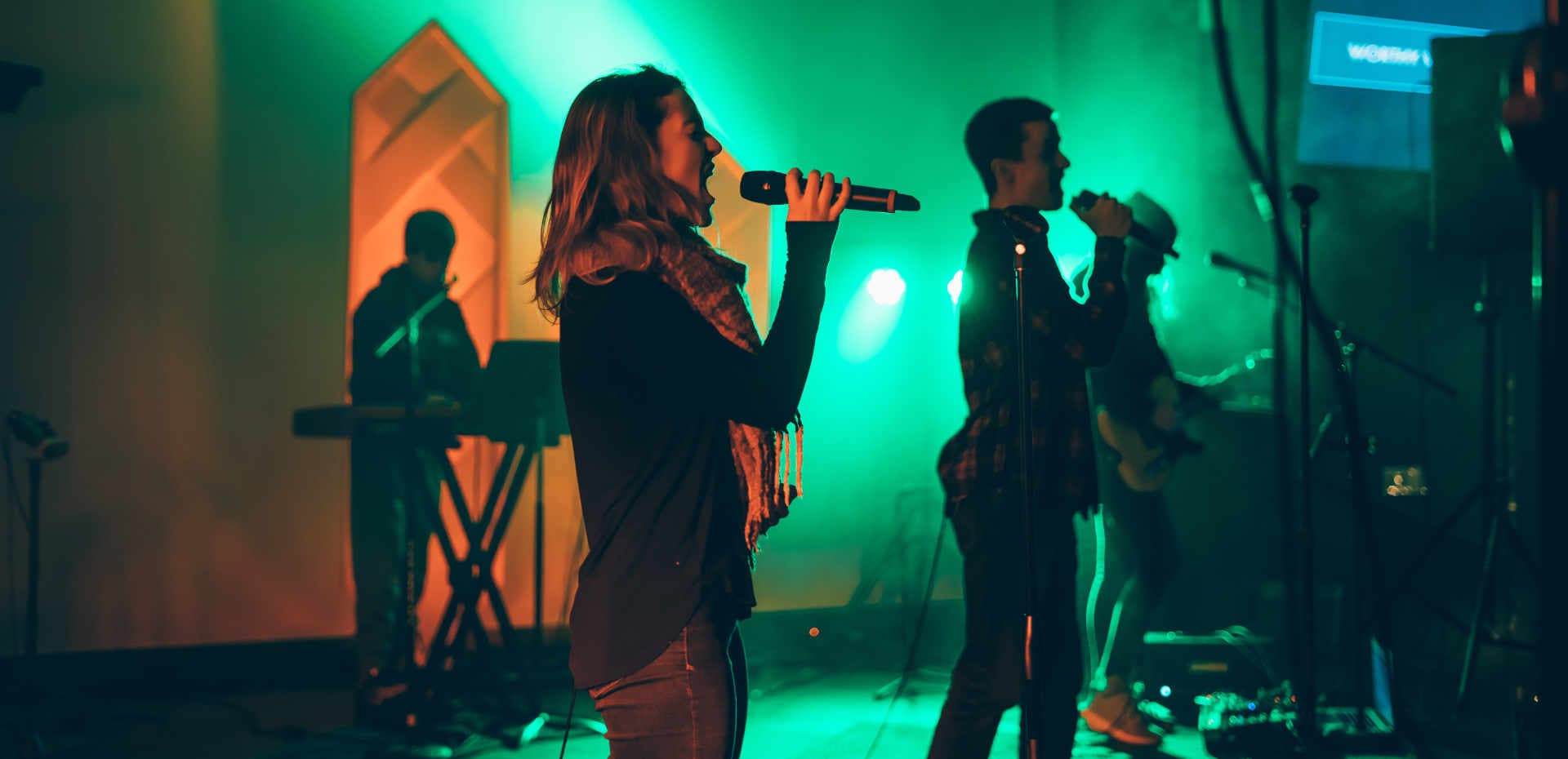 Karaoke-Auftritt mit Sängerin und Band auf einer beleuchteten Bühne
