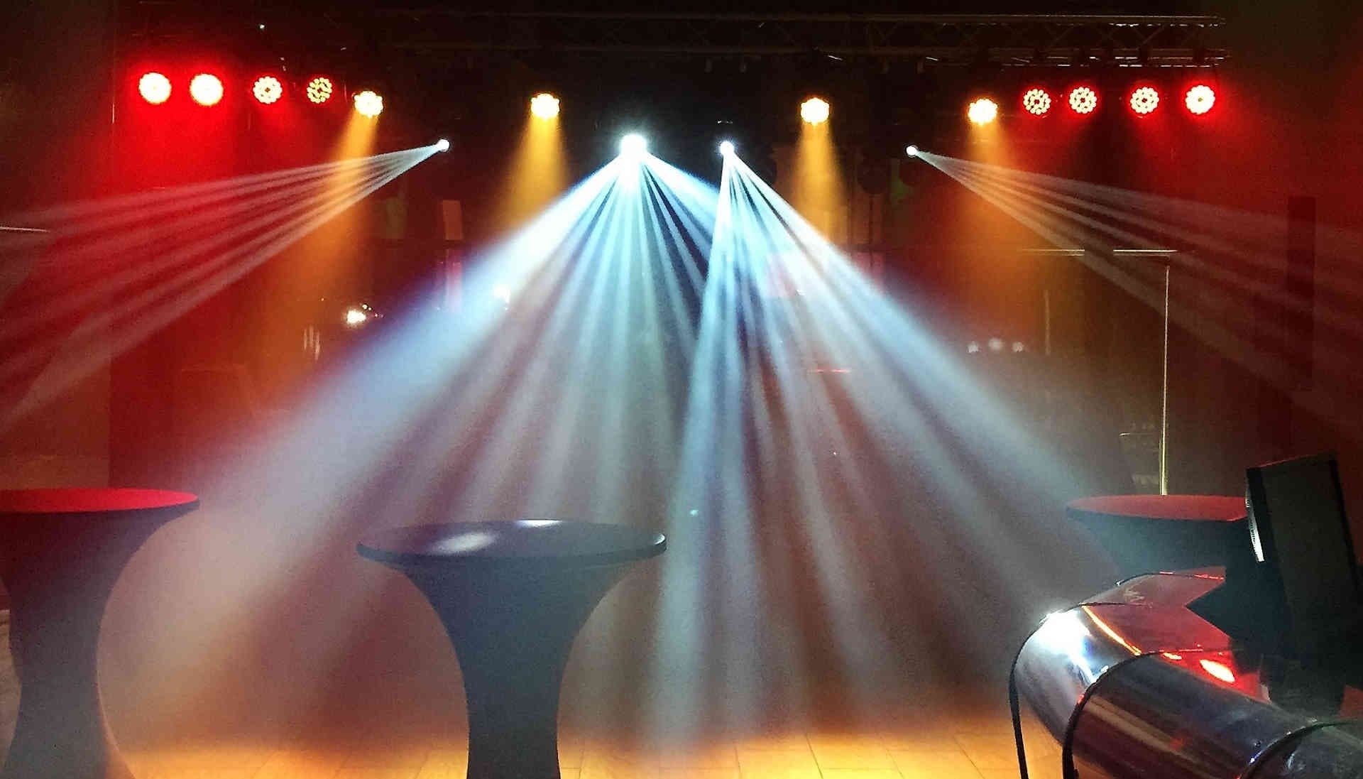 Bunte Lichtstrahlen und Stehtisch als Beispiel für sonstige Veranstaltungstechnik