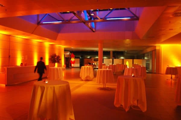 Bodenstrahler setzen einen Veranstaltungsraum in orange-blaues Licht